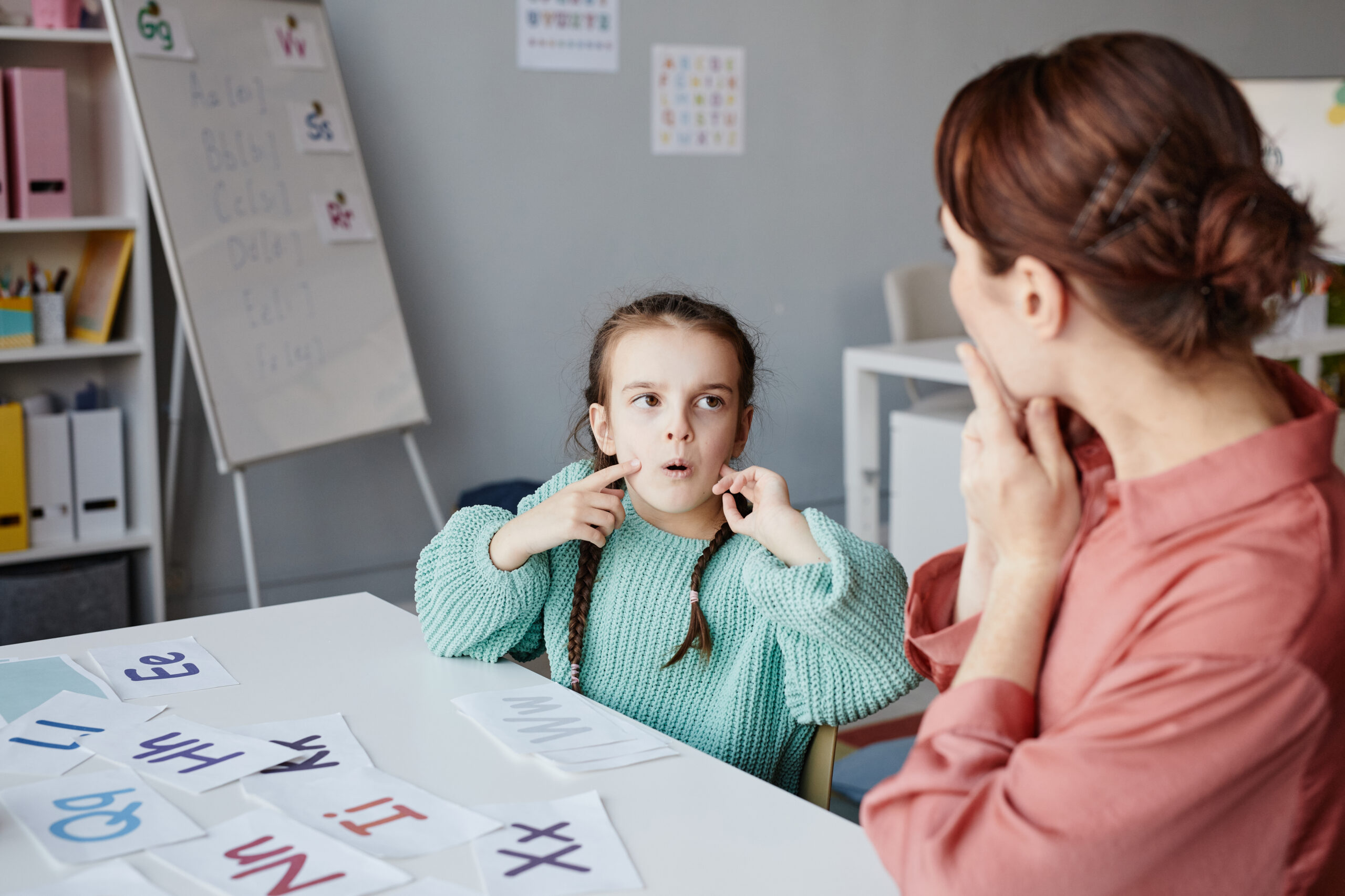 Girl with teacher studying at school