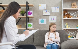 depressed-girl-sitting-sofa-with-female-psychologist-writing-note-clipboard